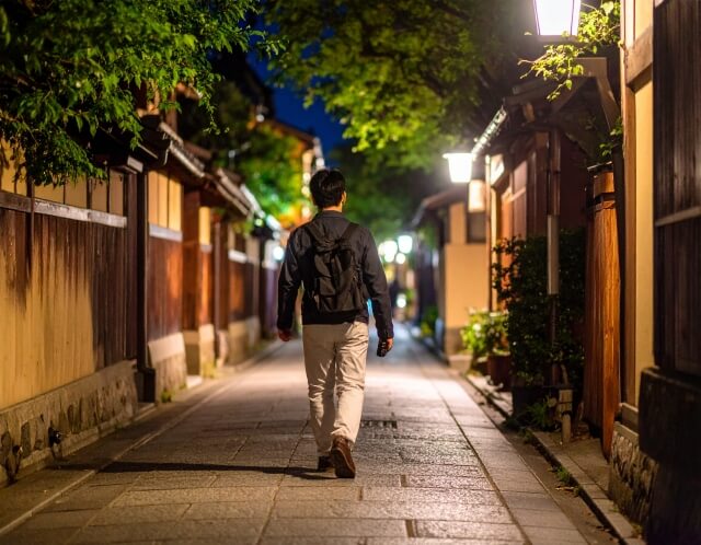 夜の住宅街を歩く男性